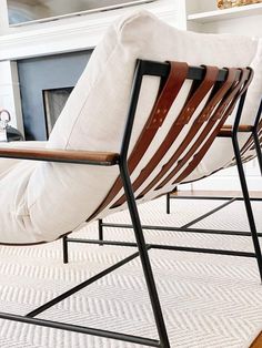 a pair of chairs sitting on top of a rug in front of a fire place