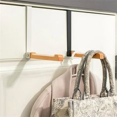 a purse hanging on the wall next to a coat rack