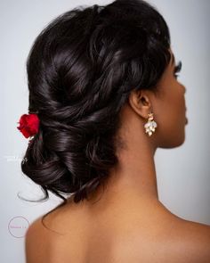 a woman with black hair and a red flower in her hair is looking off to the side