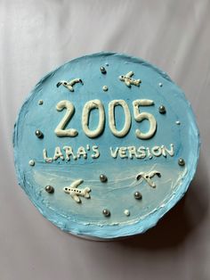 a blue cake with an airplane and the number 205 on it that says larra's version