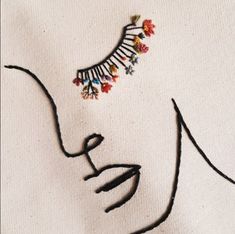 a drawing of a woman's face with flowers in her hair and an earring