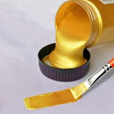 a yellow paint brush sitting on top of a container