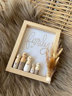 a family photo frame with five wooden pegs in it on top of a fur rug