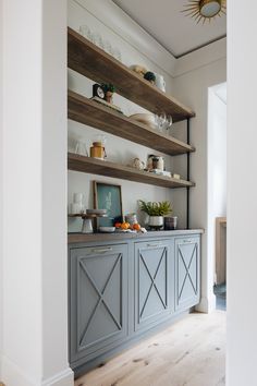 a kitchen with open shelving and wooden shelves on the wall, along with other items