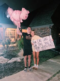 a man and woman holding a pig balloon in front of a house with a sign that says, your dad said i can't thank you to from many pigs