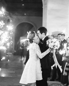 a bride and groom kissing while surrounded by sparklers