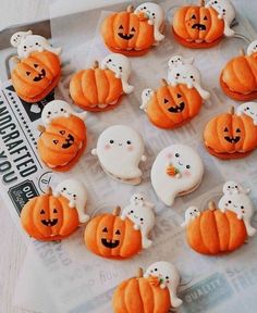 there are many decorated pumpkins and ghost cookies on the table with white frosting