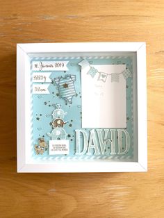 a baby's birth gift set in a white box on a wooden table top