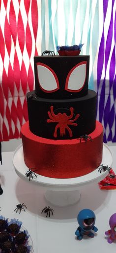 a three tiered cake with spiderman decorations on it