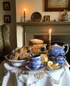 a table topped with plates and bowls filled with food next to a lit candlestick