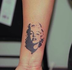 a woman's wrist tattoo with a portrait of marilyn monroe on the left side