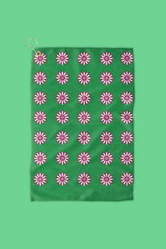 a green cloth with pink and white flower designs on it, against a green background