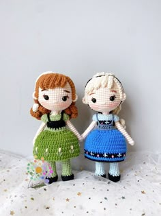 two crocheted dolls standing next to each other