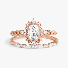 a rose gold engagement ring set with an oval cut diamond in the center and side stones