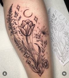 a black and white photo of a flower tattoo on the right thigh, with an moon in the background