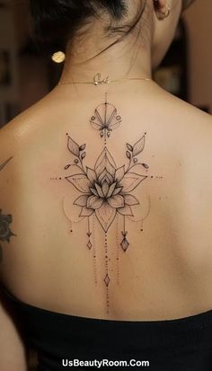 the back of a woman's shoulder with an intricate tattoo design on her upper