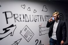 a man talking on a cell phone in front of a wall with writing and arrows