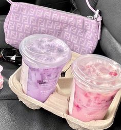 two plastic cups filled with ice cream sitting on top of a car seat