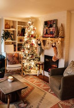 a living room filled with furniture and a christmas tree in front of a fire place