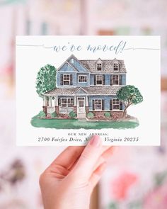 a person holding up a card with a drawing of a house in the middle of it