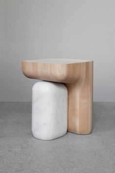 two white stools sitting next to each other on top of a gray flooring