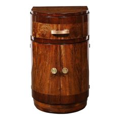 a wooden cabinet with two brass knobs on the front and bottom, sitting upright against a white background