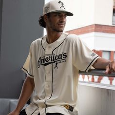 a man in a baseball uniform leaning on a railing