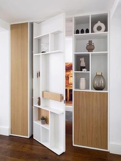 an open bookcase with shelves and vases on it