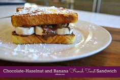 chocolate - hazelnut and banana french toast sandwich on a plate with powdered sugar