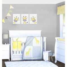 a baby's room with gray walls and white furniture, including a yellow giraffe crib