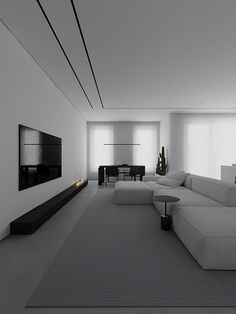 a modern living room with white walls and grey carpeted flooring, large sectional couches in front of a flat screen tv mounted on the wall