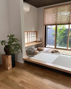 a bed room with a neatly made bed and a fan on the side of it