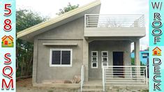 the small house is painted gray and has white railings