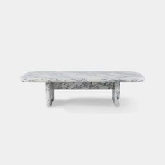 a white marble table with two legs and a long slab on the top, against a gray background