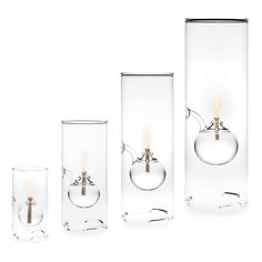 three glass vases with candles in them