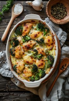 a casserole dish with broccoli, cheese and other toppings on a wooden table