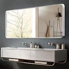 a bathroom with a large mirror above the sink and two faucets below it