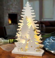 a white wooden christmas tree with lights on it's base and decorations around the base