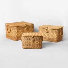 three wicker baskets with handles on each side, one is empty and the other has two