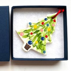 a ceramic christmas tree ornament in a box