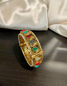 Traditional Temple Navrathan / Navratan / Multicolor Semi Precious stone studded openable Ganesh Motif Bracelet Bangle in Matte gold finish. A perfect piece of art always a keeper in your jewelry trinket that goes with Ethnic Attire /  Indian outfits.  👉🏻Size Available:  2.5 Openable  ✅Check other styles available in our store https://www.etsy.com/shop/KKsCulture Send us an email if you need help!  SHIPPING & TURNAROUND  👉🏻Please check listings for shipping and turnaround times.  👉🏻We foll Fusion Style Bracelet For Wedding And Diwali, Fusion Style Wedding Bracelet For Diwali, Fusion Style Bangle As Diwali Gift, Multicolor Temple Jewelry Bracelets For Celebration, Festive Bracelets For Celebration, Openable, Fusion Style Bracelets For Puja And Diwali, Multicolor Round Temple Jewelry Bracelets, Multicolor Round Temple Jewelry Bracelet, Festive Bangle With Stone Work For Celebration