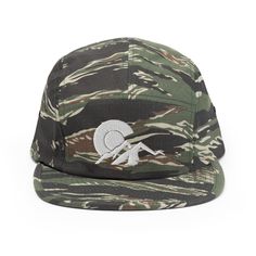 a camo cap with a white skull on the front and one eye in the center