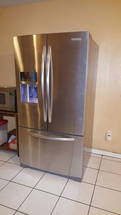 a metallic refrigerator freezer sitting inside of a kitchen