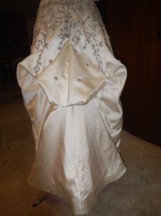 a white wedding dress on display in a room