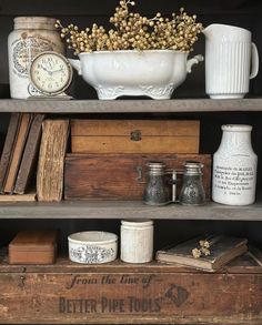 an old wooden shelf with books, jars and other items