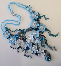 a necklace with blue beads and flowers on it