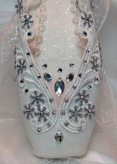 a pair of white ballet shoes covered in crystals