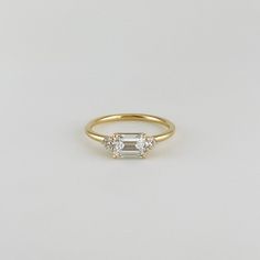 a gold ring with three stones on the side and a single stone in the middle