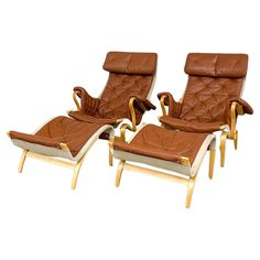 three brown leather reclining chairs sitting next to each other on top of a white floor