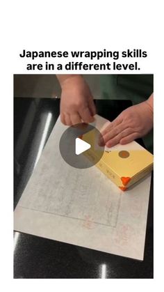 a person cutting up a piece of paper on top of a table with the caption japanese wrapping skills are in a different level